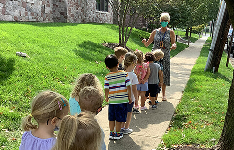 Woman kindergarten teaching with student