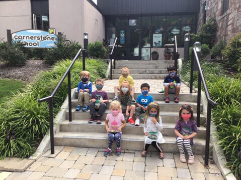 Preschoolers sitting on school steps