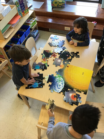 Young children playing with space puzzle