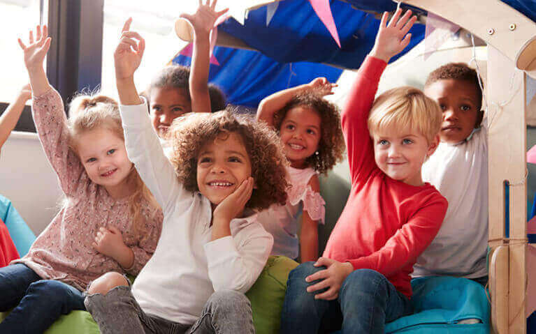 Preschool kids raising hands